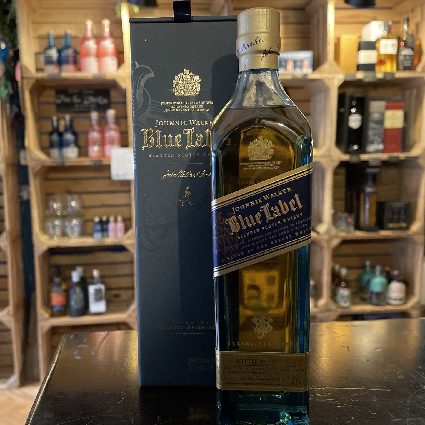 Johnnie Walker Blue Label Whisky 20cl Bottle on a table with shop shelves in the background in Barry Island Spirits Co shop on High Street in Barry