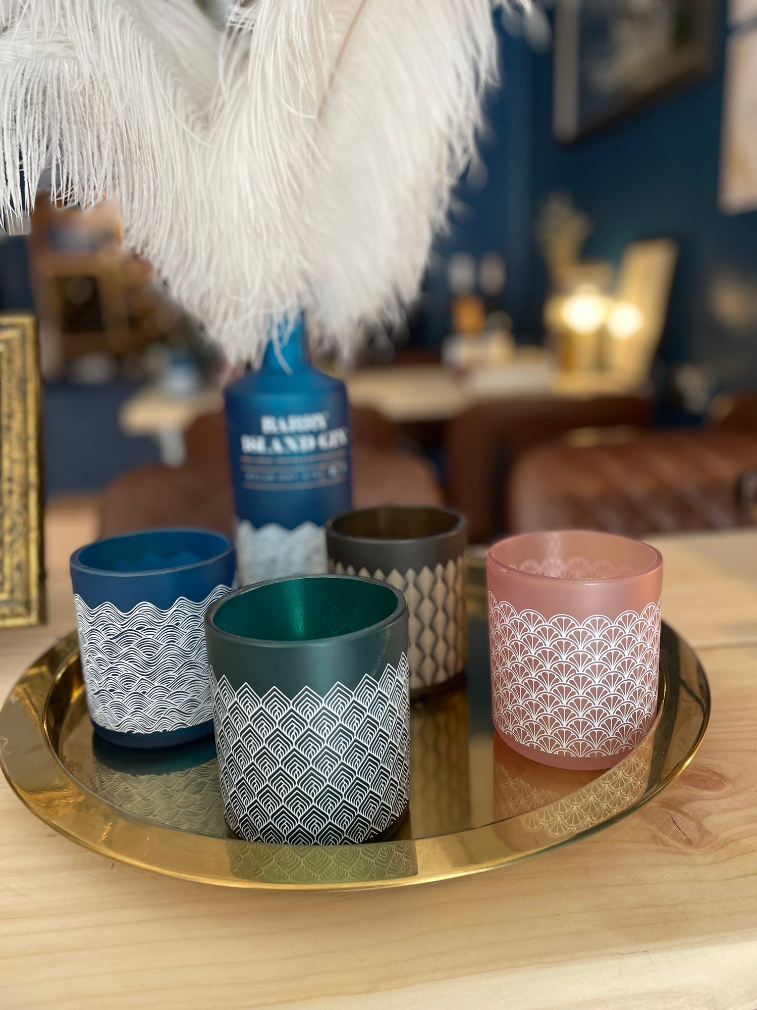 Upcycled glassware from Barry Island Spirits co, 4 glasses and a bottle on a gold tray on a table 
