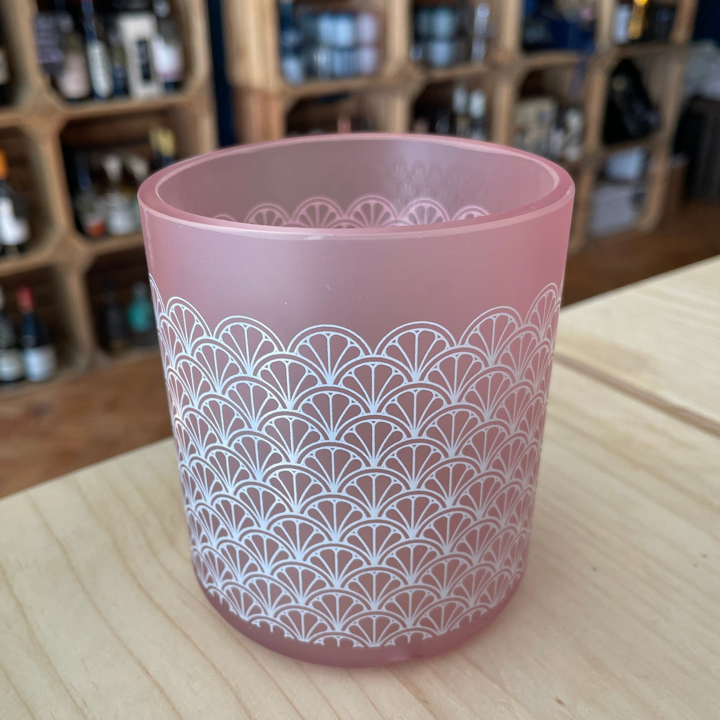 An upcycled Barry Island Pink Gin glass on a table in a shop
